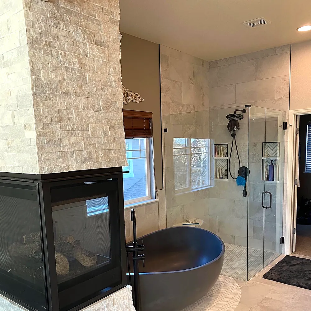 Primary bath: stacked stone fireplace and porcelain floor
